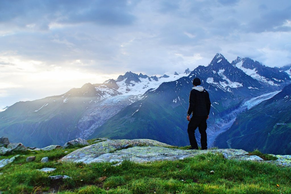 Abenteurer©Pexels Wanderer mit Blick auf die schneebedeckten berge bei Sonnenaufgang
