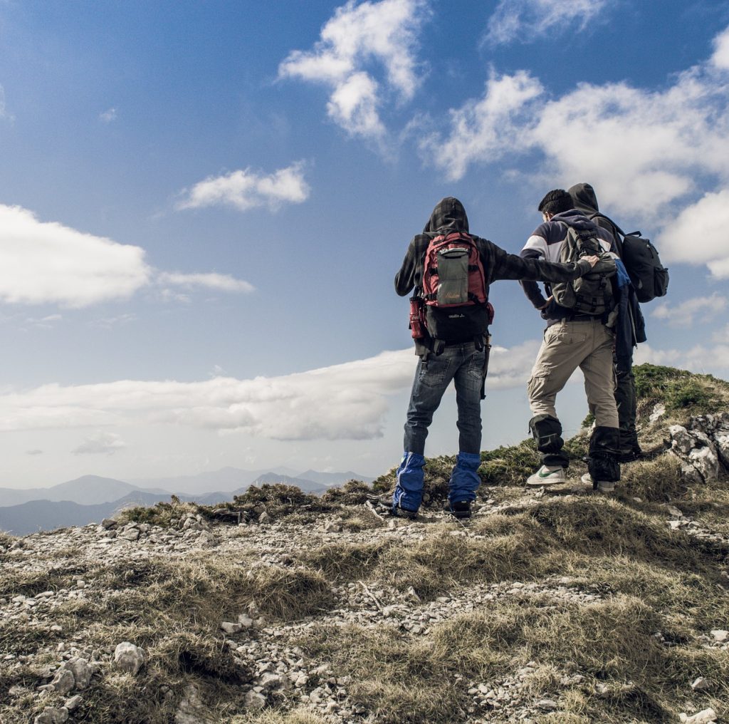 Bergsteiger am Ziel – ©StockSnap/Pixabay Drei Bergsteiger stehen auf einem Gipfel und schauen in die Ferne.