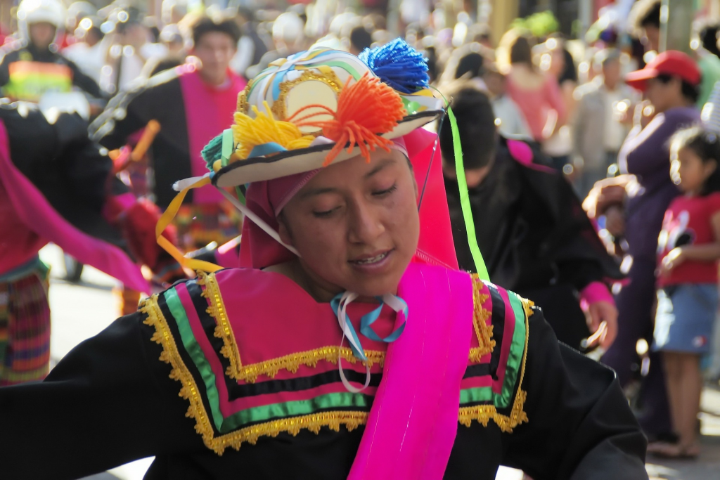 Mädchen in traditionellem Kostüm auf einem Umzug in Ecuador.