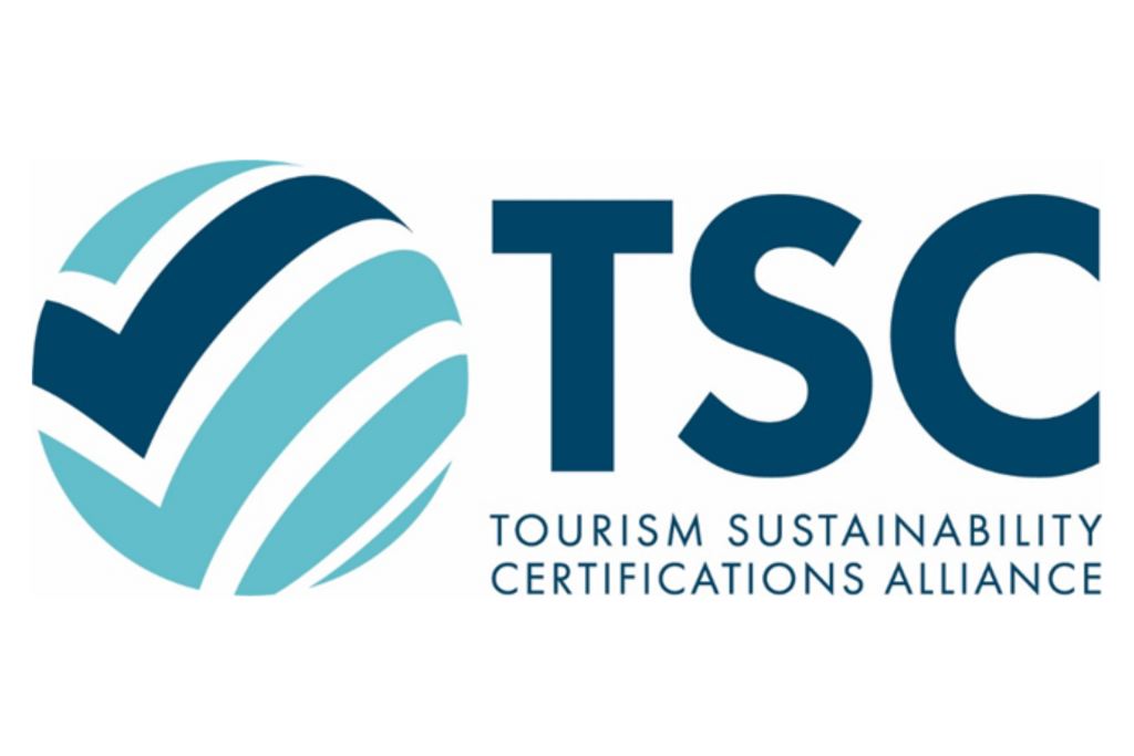 Links befindet sich ein rundes Logo, das einer türkisfarbenen Kugel mit einem dunkelblauen Häkchen ähnelt. Rechts daneben stehen die Buchstaben „TSC“, darunter ist in dunkelblauer Schrift die Beschreibung „Tourism Sustainability Certifications Alliance“ zu lesen.